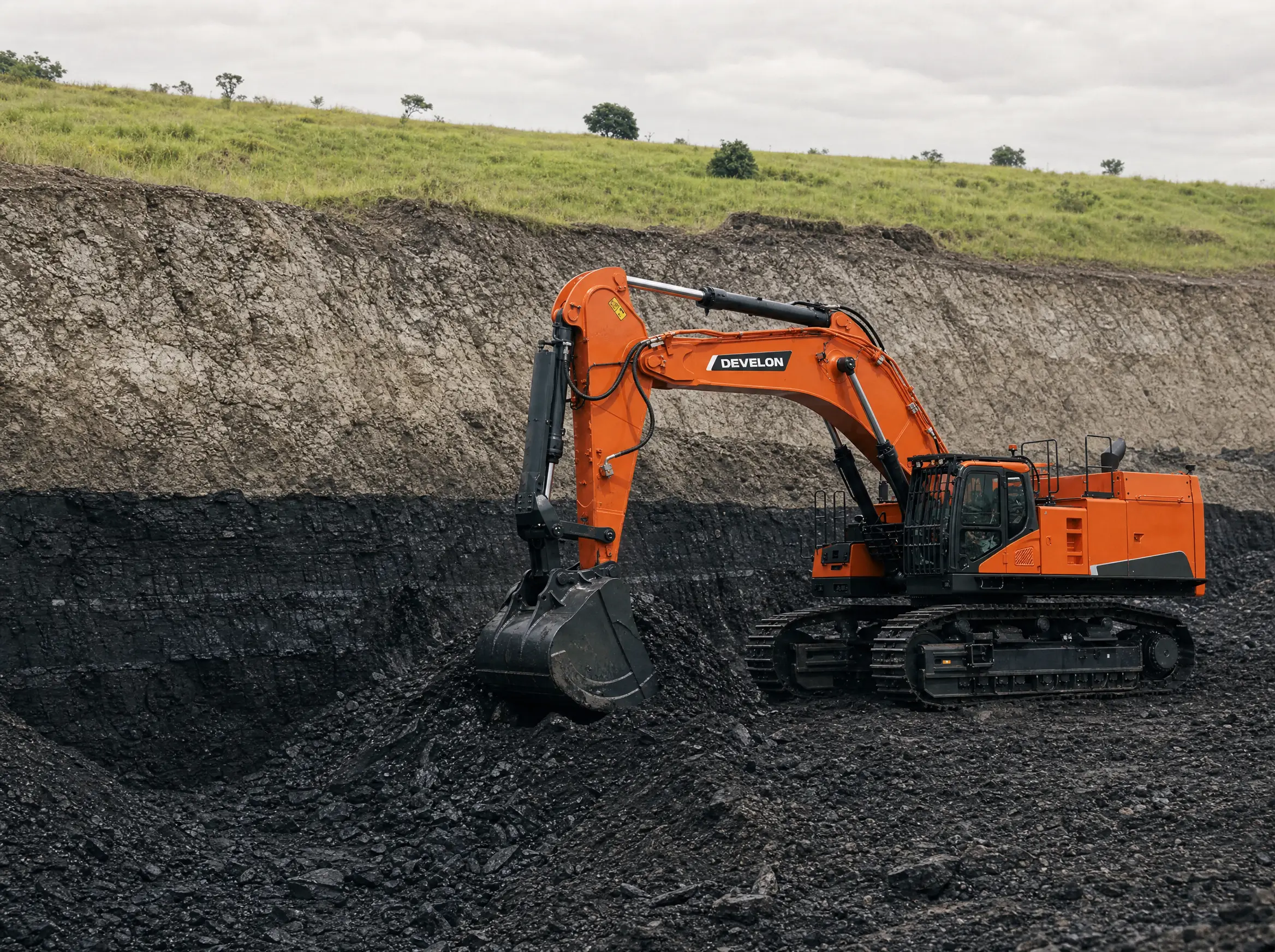 An excavator working an exposed black anthracite seam in a strip cut, the seam sharp against pale overburden
